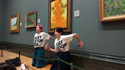Deux militantes se collent à un mur de la National Gallery de Londres (Royaume-Uni), après avoir aspergé un tableau de soupe, le 14 octobre 2022. (HANDOUT / JUST STOP OIL)