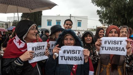 Des manifestants brandissent des pancartes "visitez la Tunisie", lors d'un rassemblement devant le mus&eacute;e du Bardo &agrave; Tunis, le 24 mars 2015. (AMINE LANDOULSI / ANADOLU AGENCY / AFP)