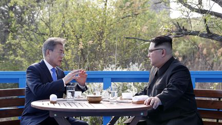 Le leader nord-coréen Kim Jong-un et le président sud-coréen Moon Jae-in discutent sur un pont près de la ligne de démarcation entre les deux pays, dans le village de Panmunjom, le 27 avril 2018 (KOREA SUMMIT PRESS POOL / KOREA SUMMIT PRESS POOL)