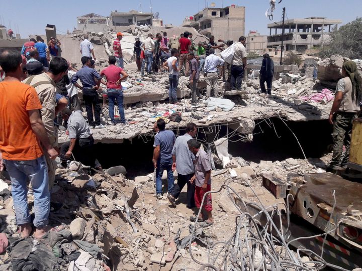 Des membres de la défense civile tentent, avec l'aide des habitants, de secourir les personnes piégées dans les décombres après l'attentat suicide, le 27 juillet 2016, dans la ville syrienne à majorité kurde de Qamichli. L'explosion qui a fait 44 morts et 140 blessés a été revendiquée par l'organisation de l'Etat islamique. (Habat Ahmed/ANADOLU AGENCY)