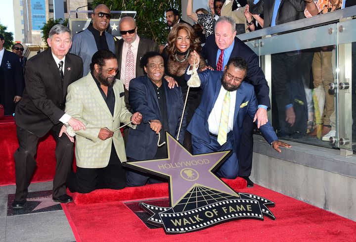 Les auteurs-compositeurs Eddie Holland (devant, à gauche), Lamont Dozier (devant, à droite) et Brian Holland (devant, à droite) sont accompagnés des musiciens Stevie Wonder, Berry Gordy et Mary Wilson lors du dévoilement de l'étoile Holland Dozier Holland sur le Hollywood Walk of fame, le 13 février 2015 à Hollywood, en Californie.&nbsp; (FREDERIC J. BROWN / AFP)