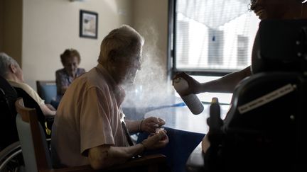 Une infirmière rafraîchit&nbsp;le pensionnaire d'un EHPAD à Lyon, le 2 juillet 2015.&nbsp; (ROMAIN LAFABREGUE / AFP)