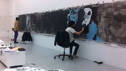 Lors de notre premier passage, nous trouvons les deux artistes dans la seconde pièce de la galerie, chacun de leur côté, concentrés sur leur travail, écouteurs aux oreilles.
 (Laure Narlian / FTV)