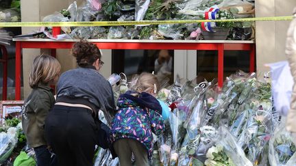 Des fleurs déposées devant le lycée Gambetta-Carnot d'Arras (Pas-de-Calais), le 14 octobre 2023, au lendemain de l'assassinat du professeur Dominique Bernard. (DENIS CHARLET / AFP)