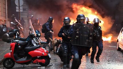 Des forces de l'ordre en pleine intervention lors de la manifestation des "gilets jaunes', le 8 décembre 2018, sur les Champs-Elysées à Paris. (ERIC FEFERBERG / AFP)