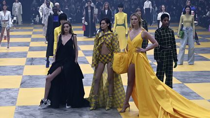 Les tops Karlie Kloss, Bella et Gigi Hadid ont défilé pour Off-White, marque du créateur américain Virgil Abloh qui a présenté une collection streetwear chic. Une longue robe jaune à traine, sac de voyage de la même couleur et escarpins pour Karlie, robe noire et baskets blanches pour Gigi, et Bella foulant le sol à carreaux jaune et gris en total look au même motif composé d'une culotte, de bottes et de long manteau ouvert: les trois looks qui résument l'essence de la collection.
 (Philippe LOPEZ / AFP)