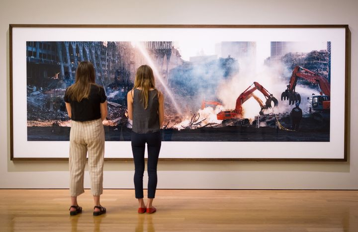 Deux visiteuses observent l'une des photos de Ground Zero prises par Wim Wenders, le 10 septembre 2021 à Londres (TOLGA AKMEN / AFP)