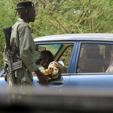 Un officier de la police camerounaise contrôle l'entrée de la petite ville de Fotokol, située à l'extrême nord du pays, afin de prévenir d'éventuelles attaques de la secte Boko Haram. (AFP PHOTO / REINNIER KAZE)