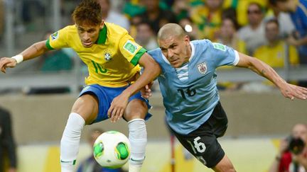 Le Brésilien Neymar au contact avec l'Uruguayen Pereira