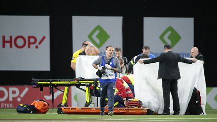 Le jeune rugbyman de Clermont Samuel Ezeala traité par les soigneurs après avoir perdu connaissance à la suite d'un violent choc, lors d'un match contre le Racing 92 à Nanterre (Hauts-de-Seine), le 7 janvier 2018. (STEPHANE ALLAMAN / AFP)