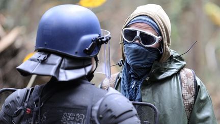 Un opposant au projet d'a&eacute;roport de Notre-Dame-des-Landes fait face &agrave; un gendarme, sur le futur terrain de l'a&eacute;roport, le 24 novembre 2012. (JEAN-SEBASTIEN EVRARD / AFP)