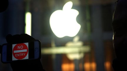 Un manifestant tient son téléphone sur lequel est inscrit «défense d'entrer», devant un Apple store, le 23 février 2016. (Jewel Samad / AFP)