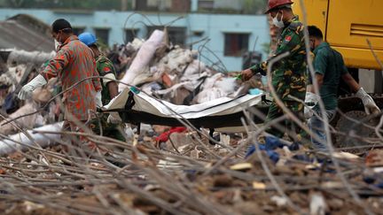 Des secouristes extraient les corps des d&eacute;combres, le 9 mai 2013 &agrave; Savar, dans la banlieue de Dacca (Bangladesh). (STR / AFP)