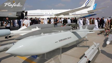 Des visiteurs émiratis et étrangers passent derrière les missiles de croisière Storm Shadow, lors de l'ouverture du salon aéronautique de Dubaï (Emirats arabes unis), le 20 novembre 2005. (RABIH MOGHRABI / AFP)