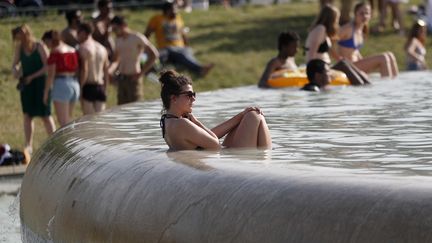 Une femme cherche un peu de fraîcheur dans la fontaine du Trocadéro à Paris, le 28 juin 2019. (ZAKARIA ABDELKAFI / AFP)