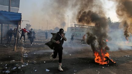 Un manifestant antigouvernemental&nbsp;lors des&nbsp;affrontements avec les forces de sécurité sur la place Tayaran, à l'est de la place Tahrir,&nbsp;à Bagdad (Irak), le 20 janvier 2020. (AHMAD AL-RUBAYE / AFP)