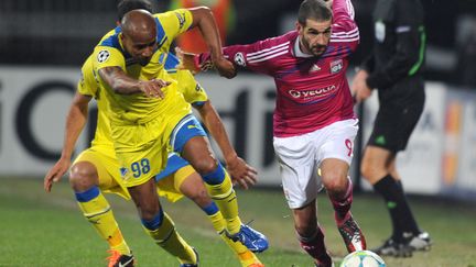 L'avant lyonnais Lisandro Lopez (&agrave; droite), &agrave; la lutte avec le d&eacute;fenseur de l'Apoel William Boaventura le 14 f&eacute;vrier 2012 au stade Gerland &agrave; Lyon (Rh&ocirc;ne). (PHILIPPE DESMAZES / AFP)