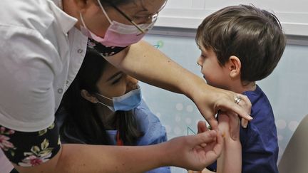 Un petit garçon se fait vacciner contre le Covid-19 le 22 novembre 2021 en Israël. (JACK GUEZ / AFP)