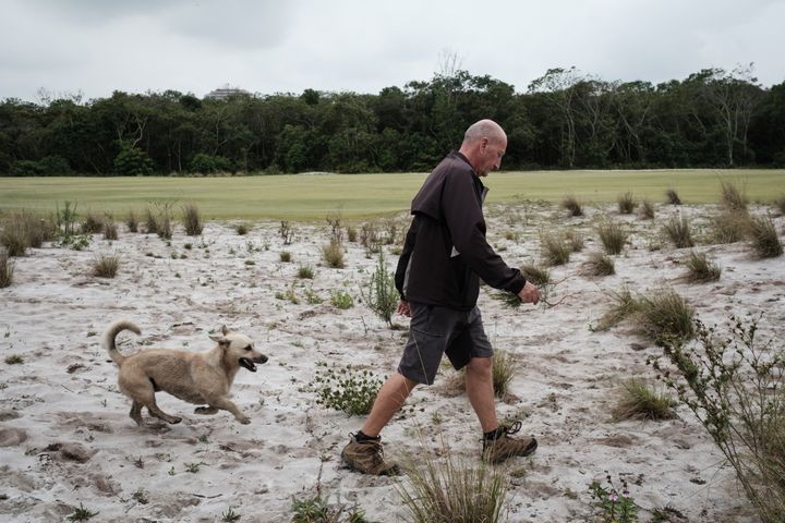 Neil Cleverly, le gérant du parcours, enlève les mauvaises herbes pour éviter leur prolifération, le 23 novembre 2016. (YASUYOSHI CHIBA / AFP)