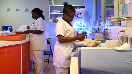 Une infirmière habille un bébé nouveau-né dans l'unité de crèche et de soins intensifs de la maternité de Mayotte, à Mamoudzou, le 14 mars 2018. (ORNELLA LAMBERTI / AFP)