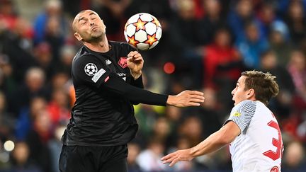 Le Lillois&nbsp;Burak Yilmaz en délicate position face au défenseur autrichien de Salzbourg, Maximilian Woeber, le 29 septembre 2021. (JOE KLAMAR / AFP)