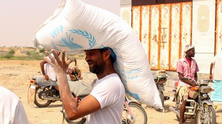 Un Yéménite transporte l'aide alimentaire du Programme alimentaire mondial. (ESSA AHMED / AFP)