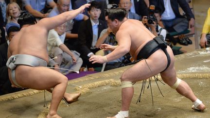 Le sumo Harumafuji (à droite) est accusé d'avoir agressé Takanoiwa (à gauche). Ici, un combat entre les deux combattants en 2016 au Japon. (KANJI / YOMIURI / AFP)