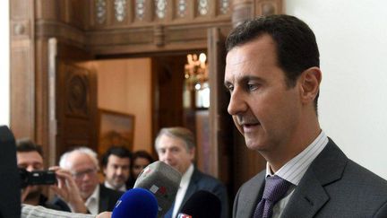 Le président syrien Bachar al-Assad à Damas le 14 novembre 2015. En arrière-plan, une délégation de parlementaires français. (HO / SYRIAN PRESIDENCY FACEBOOK PAGE / AFP)