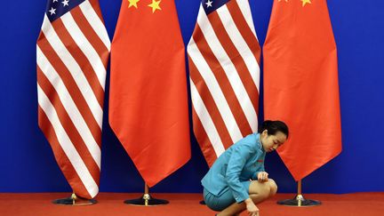 Une employ&eacute;e nettoie le tapis rouge avant le d&eacute;but de la 6e &eacute;dition des dialogues &eacute;conomiques et strat&eacute;giques entre la Chine et les Etats-Unis &agrave; P&eacute;kin (Chine), le 10 juillet 2014. (JASON LEE / REUTERS)