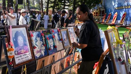 Au parc commémoratif de Ban Nam Khem, en Thaïlande, une femme dispose le portrait d'un proche tué par le tsunami. (LILLIAN SUWANRUMPHA / AFP)