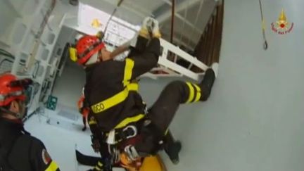 Des pompiers italiens &agrave; bord de l'&eacute;pave du "Costa Concordia", le bateau de croisi&egrave;re &eacute;chou&eacute; au large de l'&icirc;le italienne du Giglio, le 19 janvier 2012. (FTVi / APTN)