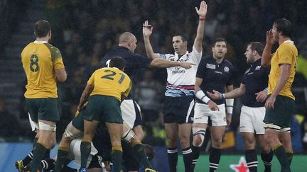 Ici au centre, l'arbitre sud-africain Craig Joubert, une fois de plus au cœur d'une polémique à cause d'une décision plus que douteuse qui avait permis à l'Australie de s'imposer 35-34 contre l'Ecosse en quart de finale de Coupe du monde. (ADRIAN DENNIS / AFP)