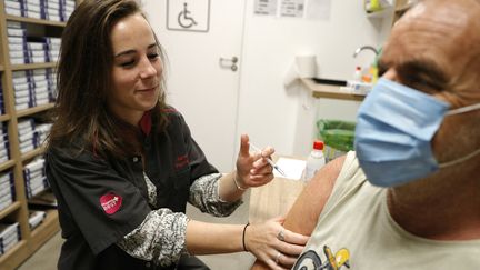 Un homme reçoit une injection d'un vaccin contre le Covid-19 dans une pharmacie à Ajaccio (Corse-du-Sud), le 5 octobre 2023. (PASCAL POCHARD-CASABIANCA / AFP)