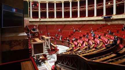 Des députés votent à mains levées le projet de loi d'urgence sanitaire, le 22 mars 2020, à l'Assemblée nationale, à Paris.&nbsp; (LUDOVIC MARIN / AFP)