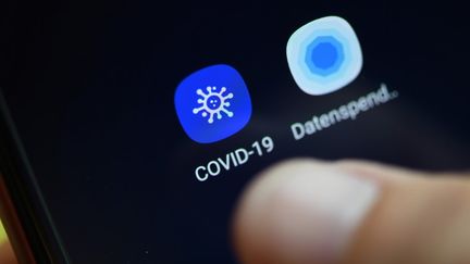 En France, le gouvenement envisage la mise en place d'une application pour suivre les déplacements des malades du Covid-19 mais elle suscite déjà des craintes sur une possible surveillance de masse. (INA FASSBENDER / AFP)