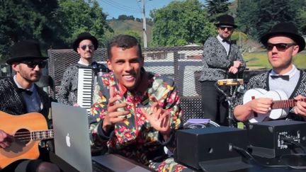 Stromae et ses musiciens jouent &agrave; l'arri&egrave;re d'une camionnette sur un route des Etats-Unis dans une vid&eacute;o mise en ligne le 1er octobre 2015. (BILLBOARD / YOUTUBE)