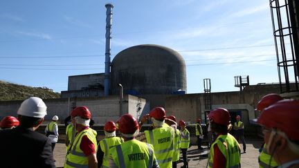 Des visiteurs photographiés devant le réacteur nucléaire de la centrale EDF de Flamanville (Manche), le 28 septembre 2015. (CHARLY TRIBALLEAU / AFP)