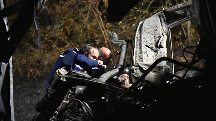 Des gendarmes examinent la carcasse du car impliqu&eacute; dans l'accident de Puisseguin (Gironde), le 23 octobre 2015. (JEROME GROISARD / MINISTERE DE L'INTERIEUR / AFP)