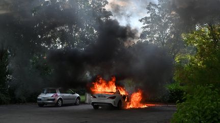 Une voiture en flammes après des affrontements dans le quartier de Grésilles, à Dijon (Côte-d'Or), le 15 juin 2020. (PHILIPPE DESMAZES / AFP)