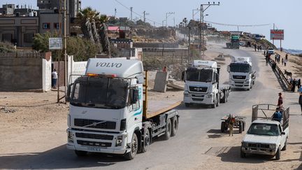 Des camions se dirigent vers l'embarcadère installé par l'armée américaine pour acheminer l'aide humanitaire à Gaza, le 17 mai 2024. (KHAMES ALREFI / AFP)