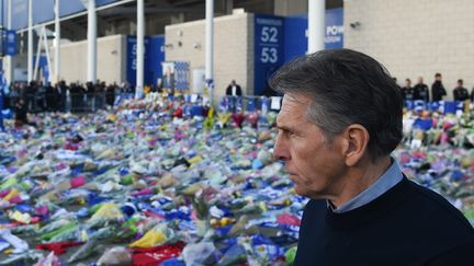 L'entraîneur français de Leicester City Claude Puel, devant les fleurs déposées en mémoire des victimes de l'accident d'hélicoptère du 27 novembre 2018. Le propriétaire du club,&nbsp;VichaiSrivaddhanaprabha a été tué. (PAUL ELLIS / AFP)