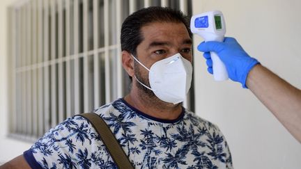 Prise de température dans un centre de test au nouveau coronavirus à Madrid (Espagne), le 17 août 2020. (OSCAR DEL POZO / AFP)