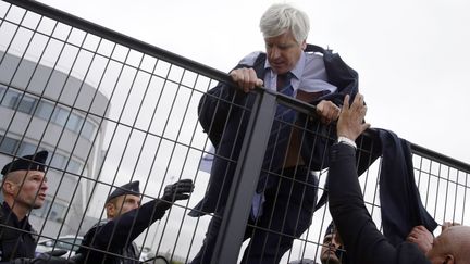 Le directeur des activit&eacute;s long courrier d'Air France escalade une grille de s&eacute;curit&eacute; pour &eacute;chapper &agrave; ses agresseurs, le 5 octobre 2015 au si&egrave;ge d'Air France, &agrave; Roissy (Val-d'Oise). (KENZO TRIBOUILLARD / AFP)