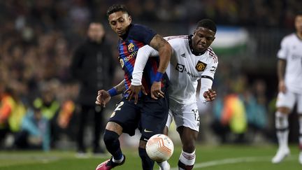 Raphinha et Tyrell Malacia lors de Barcelone-Manchester United en Ligue Europa, le 16 février 2023. (ADRIA PUIG / AFP)