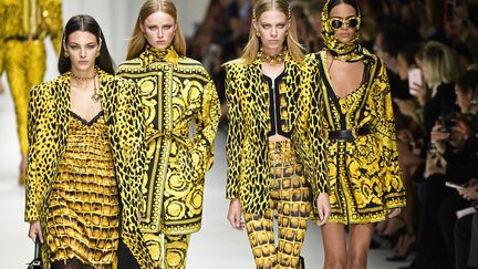 Donatella Versace s'est assuré le clou du spectacle de la fashion week avec un défilé on ne peut plus glamour de mannequins vedette, dédié à la mémoire de son frère Gianni. Une fois le rideau blanc levé à la fin de la présentation de la collection, les mannequins Cindy Crawford, Carla Bruni, Naomi Campbell, Helena Christensen et Claudia Schiffer, toutes d'or vêtues, sont apparues sous les acclamations du public. "Gianni, c'est pour toi", a lancé une voix, en mémoire du grand couturier assassiné il y a 20 ans à Miami. Pantalons aux couleurs vives, dessins baroques pour des robes parfois inspirées par le pop art d'Andy Warhol ou le cuir des rockers, ont enthousiasmé les fashionistas.
 (Miguel MEDINA / AFP)