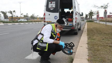 A Zaka volunteer searches for traces of blood at the scene of a knife attack in Beersheba, March 23, 2022. (ABIR SULTAN / EPA)