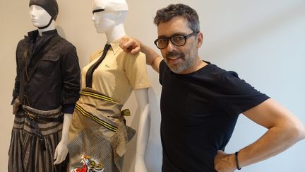 Olivier Châtenet pose à côté d'une silhouette composée d'un polo Lacoste en piqué de coton beige 1940 avec une veste chemise brodée de Yamamoto Kanzai 1980, cravate Hermès
 (Corinne Jeammet)