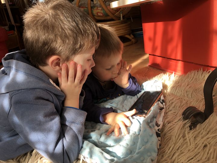 Les enfants d'Oksana regardent un dessin animé sur un téléphone,&nbsp;le 1er mars 2022, à Bieniewice (Pologne). (RAPHAEL GODET / FRANCEINFO)