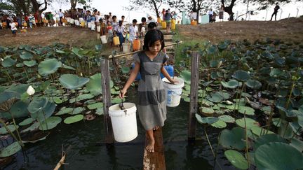 Des villageois font la queue pour collecter l'eau potable du lac&nbsp;Yazarthingyan pr&egrave;s de Rangoon (Birmanie), le 12 mai 2013. (SOE ZEYA TUN / REUTERS)