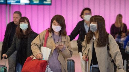 Des passagers portent des masques pour se protéger du coronavirus 2019-nCoV, à l'aéroport de Los Angeles (Californie, Etats-Unis), le 22 janvier 2020. (Mark RALSTON / AFP)